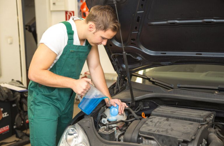 Pouring coolant in the radiator of a vehicle